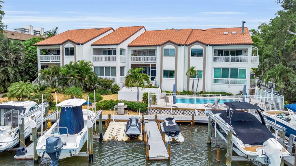 An exterior view of a multi-story residential building with a tiled roof and attached garages — 862 HUDSON AVENUE UNIT 862, SARASOTA, FL