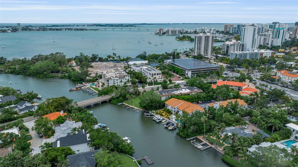A wooden dock features two covered jet skis and two boats on lifts along a canal — 862 HUDSON AVENUE UNIT 862, SARASOTA, FL