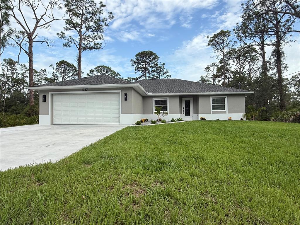 A single-story house with a gray exterior, white trim, and a two-car garage — 1317 BISCAYNE DRIVE, PORT CHARLOTTE, FL