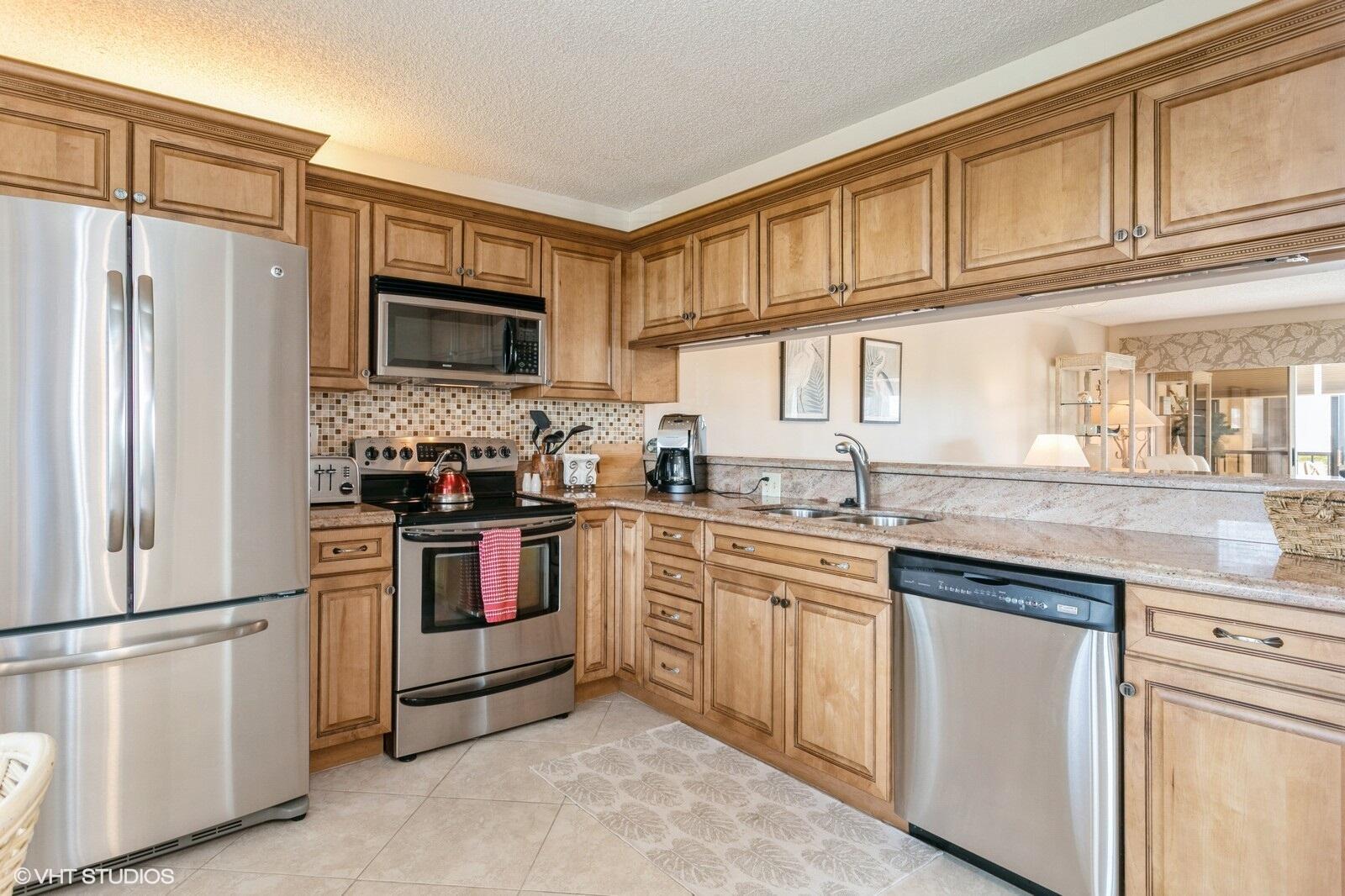 A kitchen with wood cabinets, stainless steel appliances, and granite countertops — 275 Palm Avenue # B403, Jupiter FL 33477, JUPITER, FL