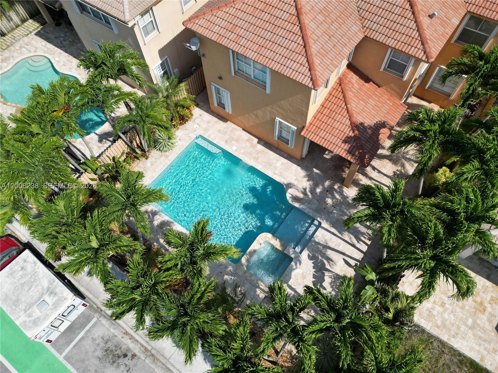 An aerial view shows a house with a tiled roof, a swimming pool, and palm trees — 11480 NW 82th Terrace, Doral FL 33178, DORAL, FL