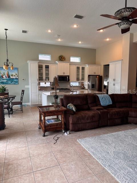 A living room features a fireplace media console, a television, and tile flooring — 9512 SERRA COURT, HOWEY IN THE HILLS, FL