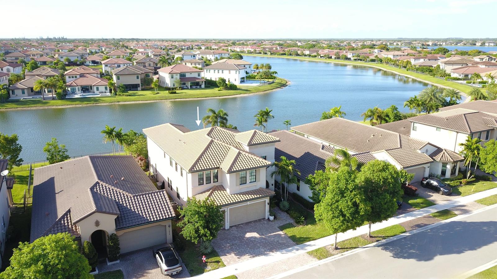 An aerial view shows a two-story suburban house with a tiled roof near a lake — 11965 S Baypoint Circle, Parkland FL 33076, PARKLAND, FL