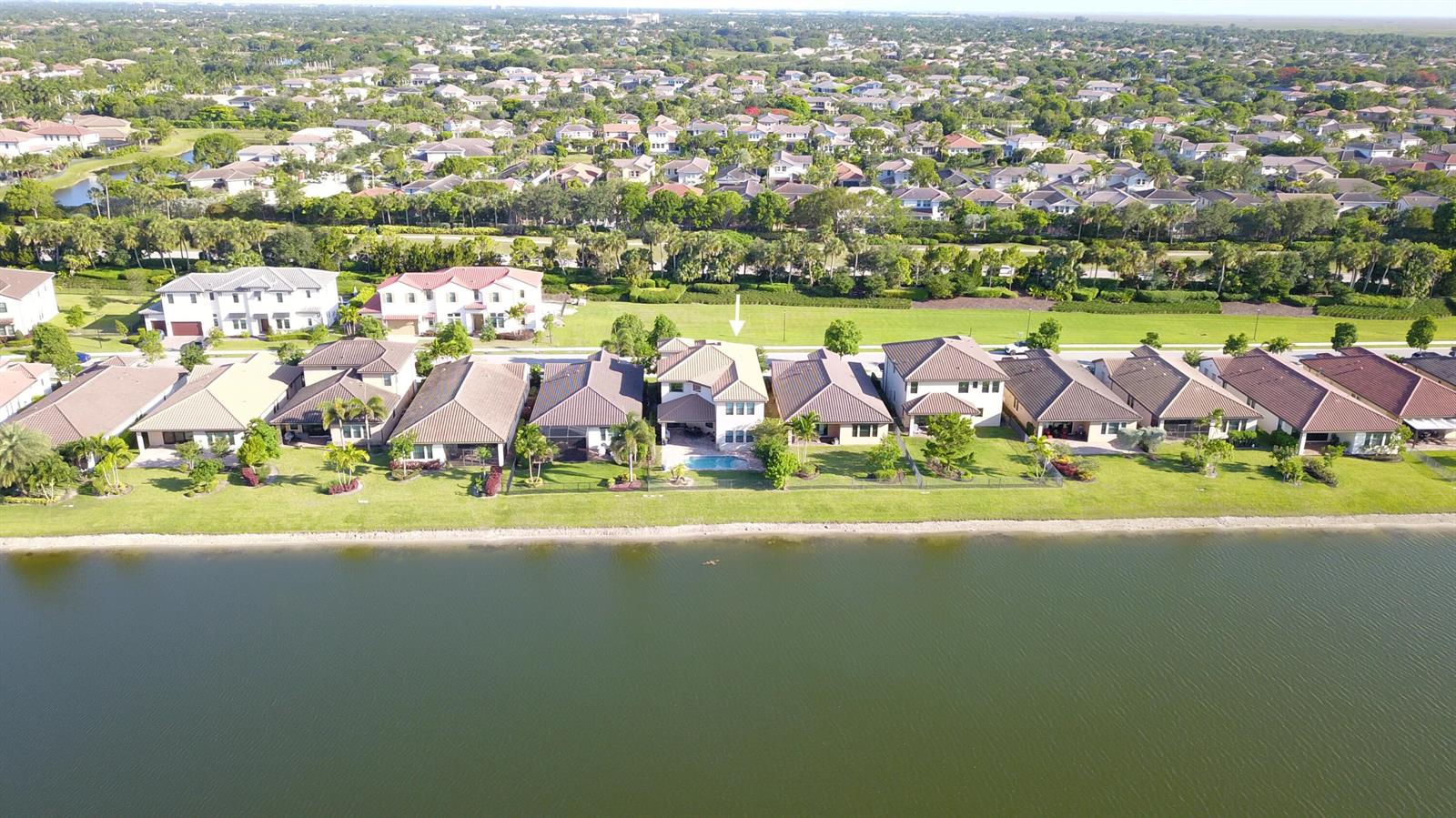 An aerial view shows a row of suburban houses along a lake with a pool — 11965 S Baypoint Circle, Parkland FL 33076, PARKLAND, FL