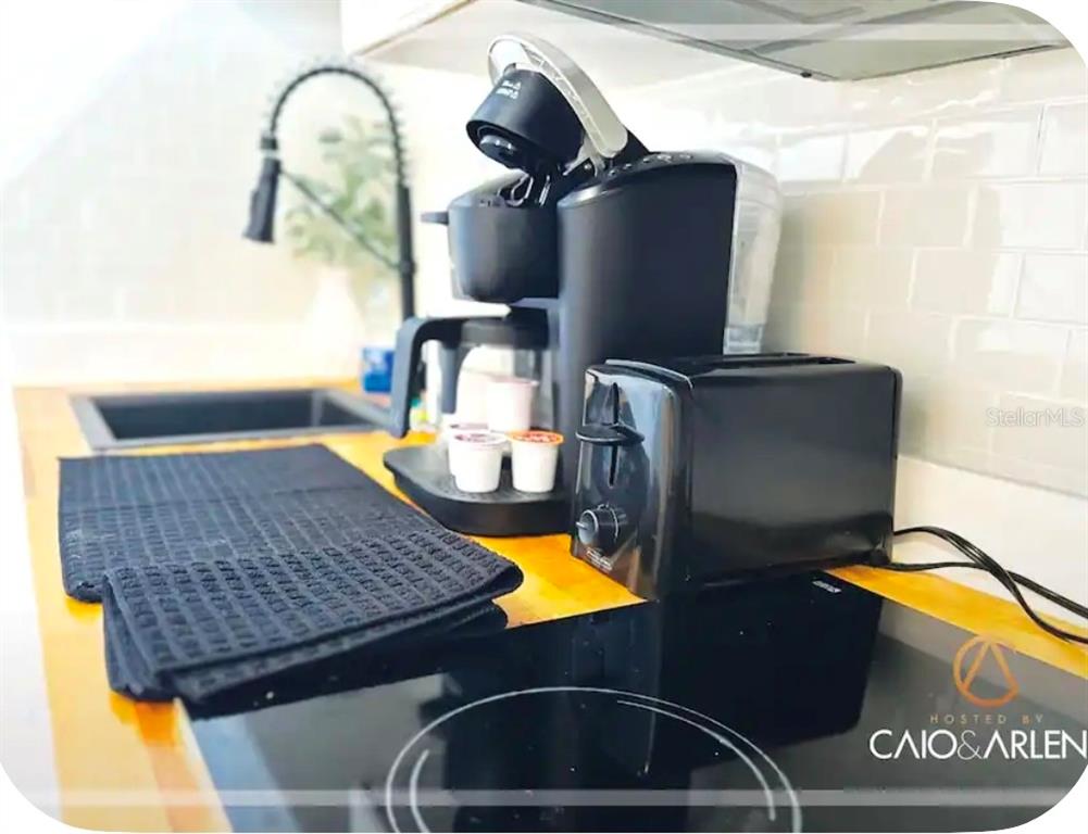 A kitchen counter features a coffee maker, a toaster, and a black drying mat — 2700 N ATLANTIC AVENUE UNIT 915, DAYTONA BEACH, FL
