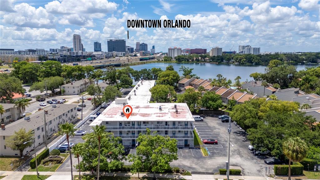 An aerial view shows a multi-story apartment building with a parking lot near a lake — 320 LAKEVIEW STREET UNIT 323, ORLANDO, FL
