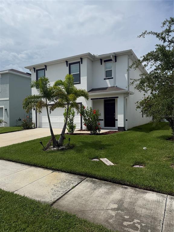 A two-story white house with a two-car garage and a concrete driveway at sunset — 15990 TUSCANY HILLSIDE ROAD, ODESSA, FL