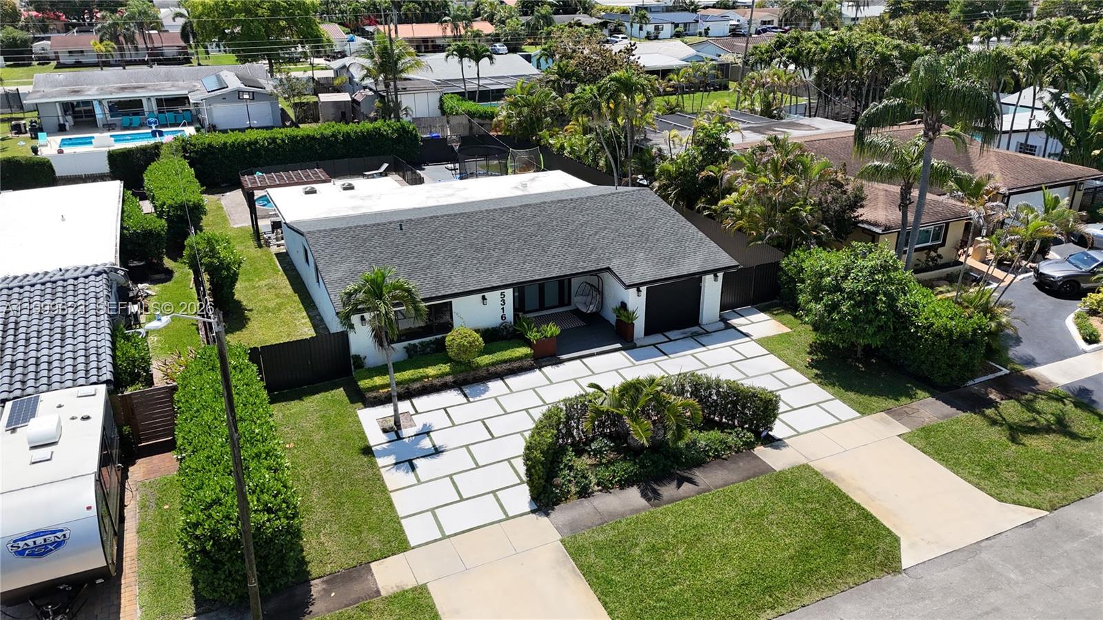An aerial view shows a single-story house with a paved driveway and landscaped front yard — 5316 Jackson St, Hollywood FL 33021, HOLLYWOOD, FL