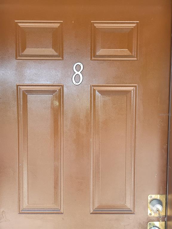 A brown, four-panel front door features the number eight mounted in the center — 1216 KENNEDY ROAD UNIT 8, DAYTONA BEACH, FL