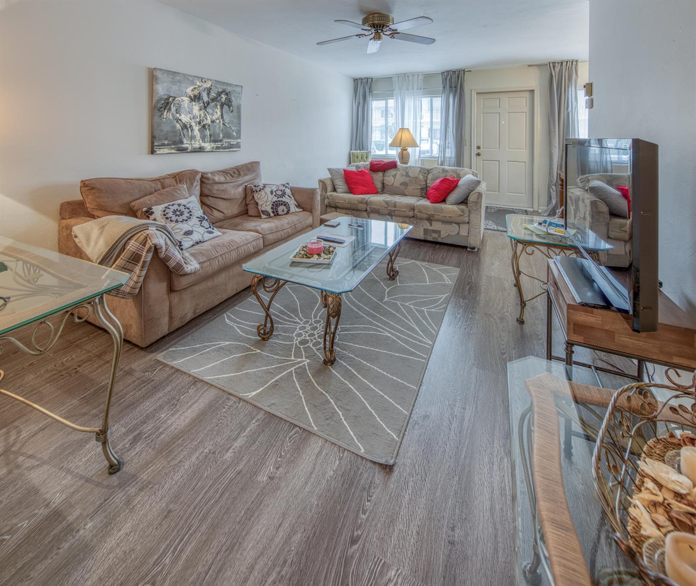 A living room features a brown sofa, a patterned sofa, a glass coffee table, and flooring — 3040 Lake Osborne Drive # 106, FL 33461, FL