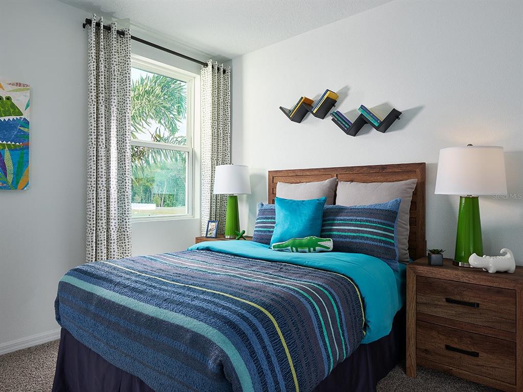 A bedroom features a bed with blue striped bedding, green lamps, and wall-mounted shelves — 102 WANDERING CREEK WAY, PALM COAST, FL