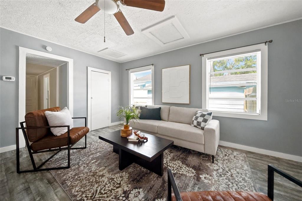 A living room features gray walls, a beige sofa, two leather chairs, and a rug — 109 E BASS STREET, KISSIMMEE, FL