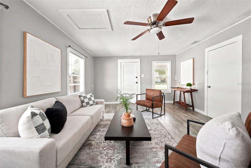 A living room features a light gray sofa, two leather chairs, and a dark coffee table — 109 E BASS STREET, KISSIMMEE, FL