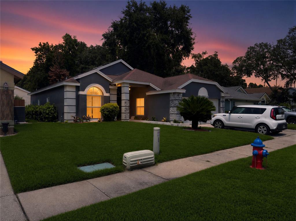 A single-story house with a gray exterior, arched window, and a red fire hydrant nearby — 1409 WOODFIELD OAKS DRIVE, APOPKA, FL