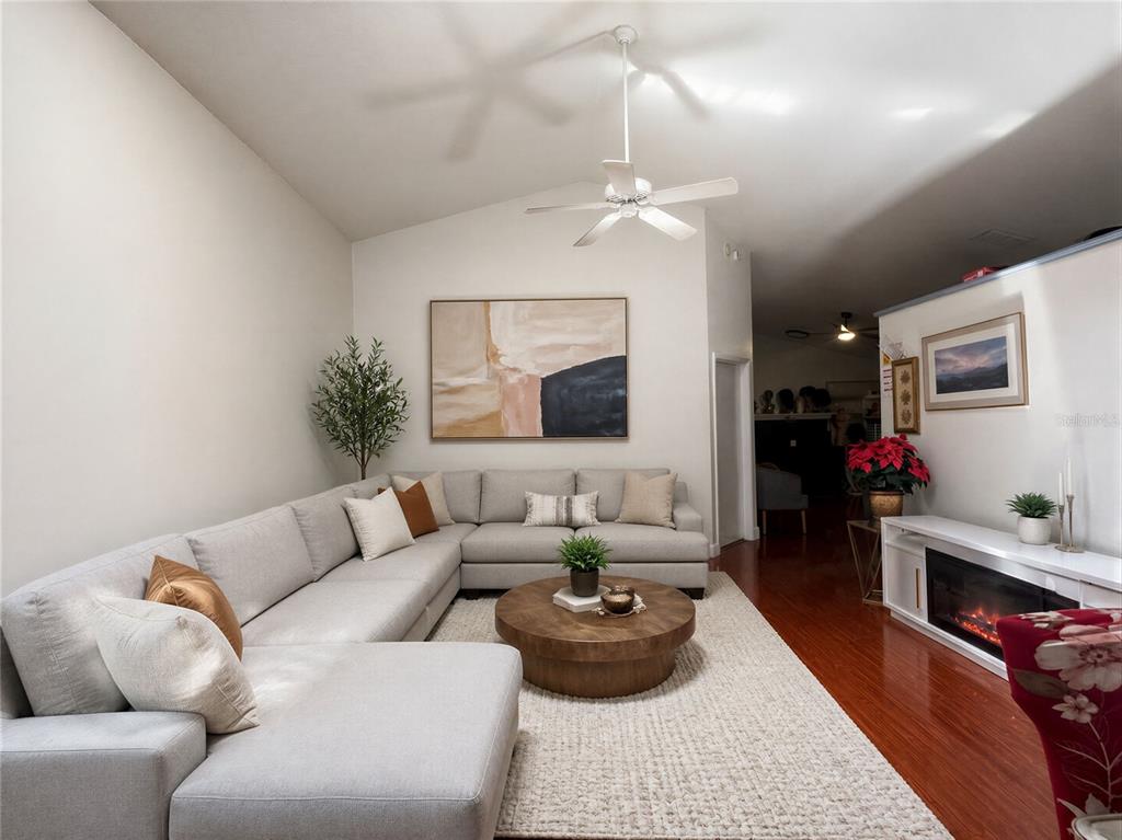 A living room features a large sectional sofa, a round coffee table, and a fireplace — 1409 WOODFIELD OAKS DRIVE, APOPKA, FL
