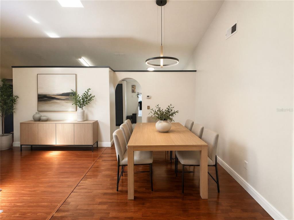 A dining room features a wooden table, six chairs, a sideboard, and a modern pendant light — 1409 WOODFIELD OAKS DRIVE, APOPKA, FL