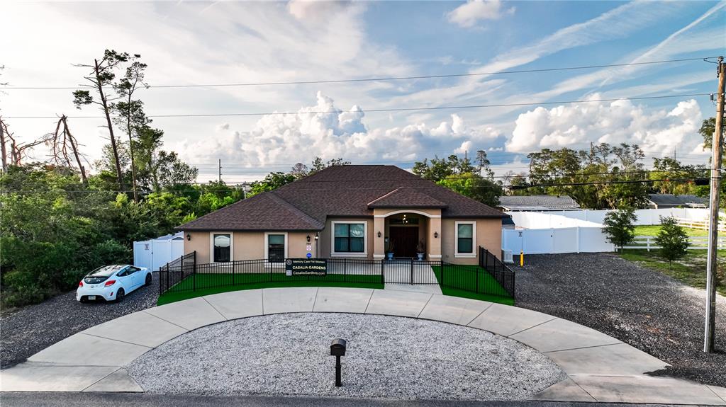 A single-story tan house with a dark roof and a semi-circular concrete driveway — 13031 PARTRIDGE STREET, SPRING HILL, FL