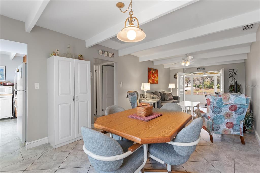 A dining area with a wooden table and chairs opens into a living room — 1919 CLUB CIRCLE, LAKE WALES, FL