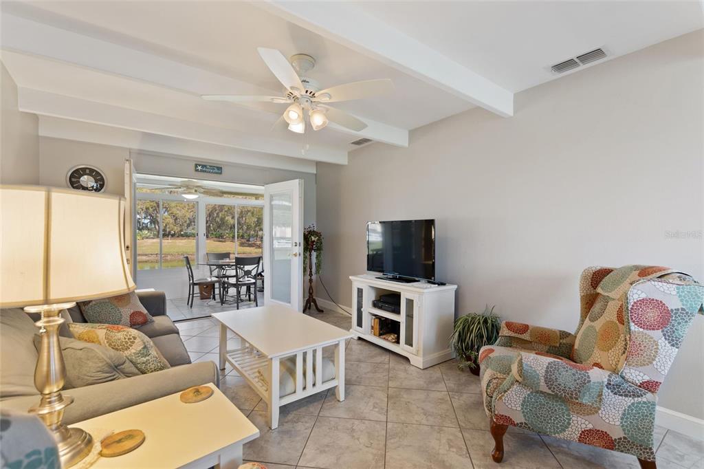 A living room with tile floors, a ceiling fan, and a view of a patio — 1919 CLUB CIRCLE, LAKE WALES, FL