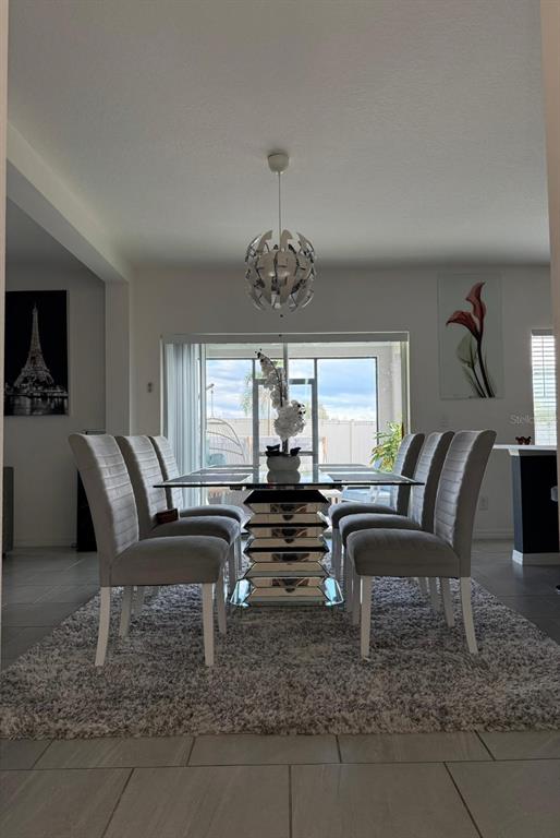 A dining room features a glass-topped table with a mirrored base and six upholstered chairs — 425 TORTUGAS STREET, HAINES CITY, FL