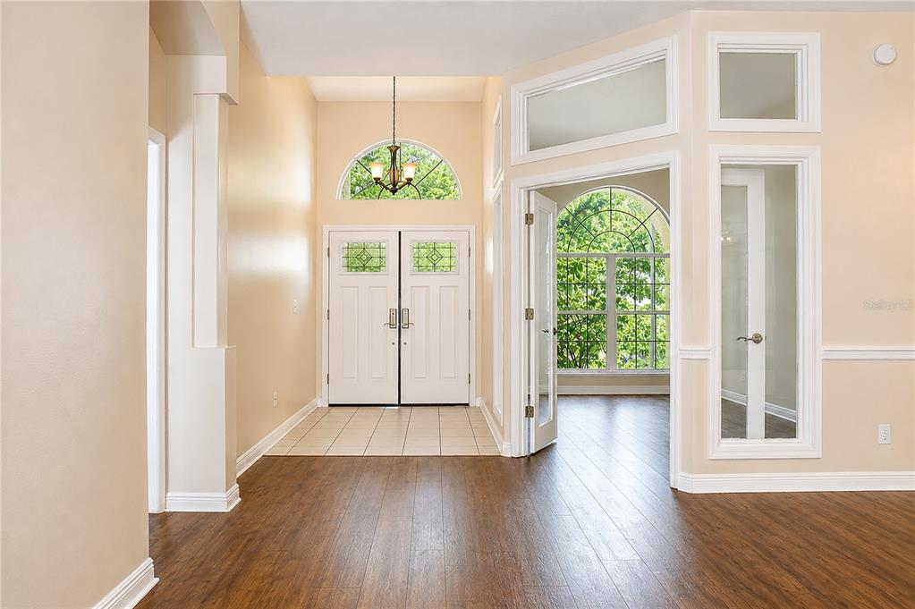 A foyer with wood flooring, a tiled entryway, double front doors, and glass-paneled French doors — 5622 GLENCREST BOULEVARD, TAMPA, FL