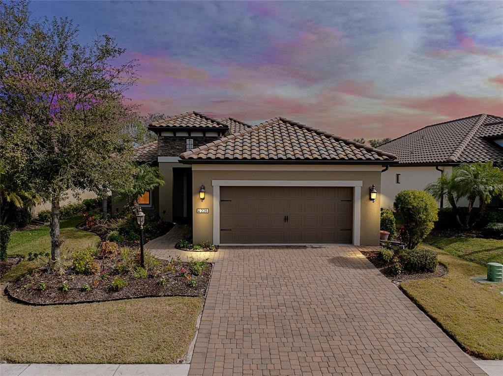 A single-story house with a tiled roof, tan stucco exterior, and a paved driveway — 228 ACERNO DRIVE, NOKOMIS, FL