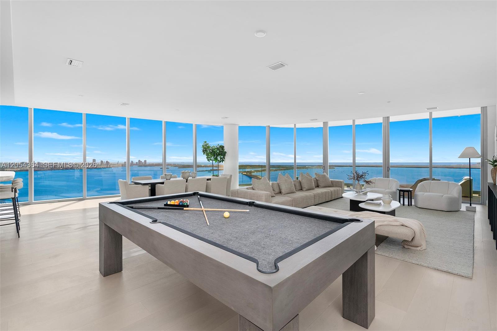 A modern living room features a pool table, neutral furniture, and floor-to-ceiling windows overlooking water — 175 SE 25th Rd # 4001, Miami FL 33129, MIAMI, FL