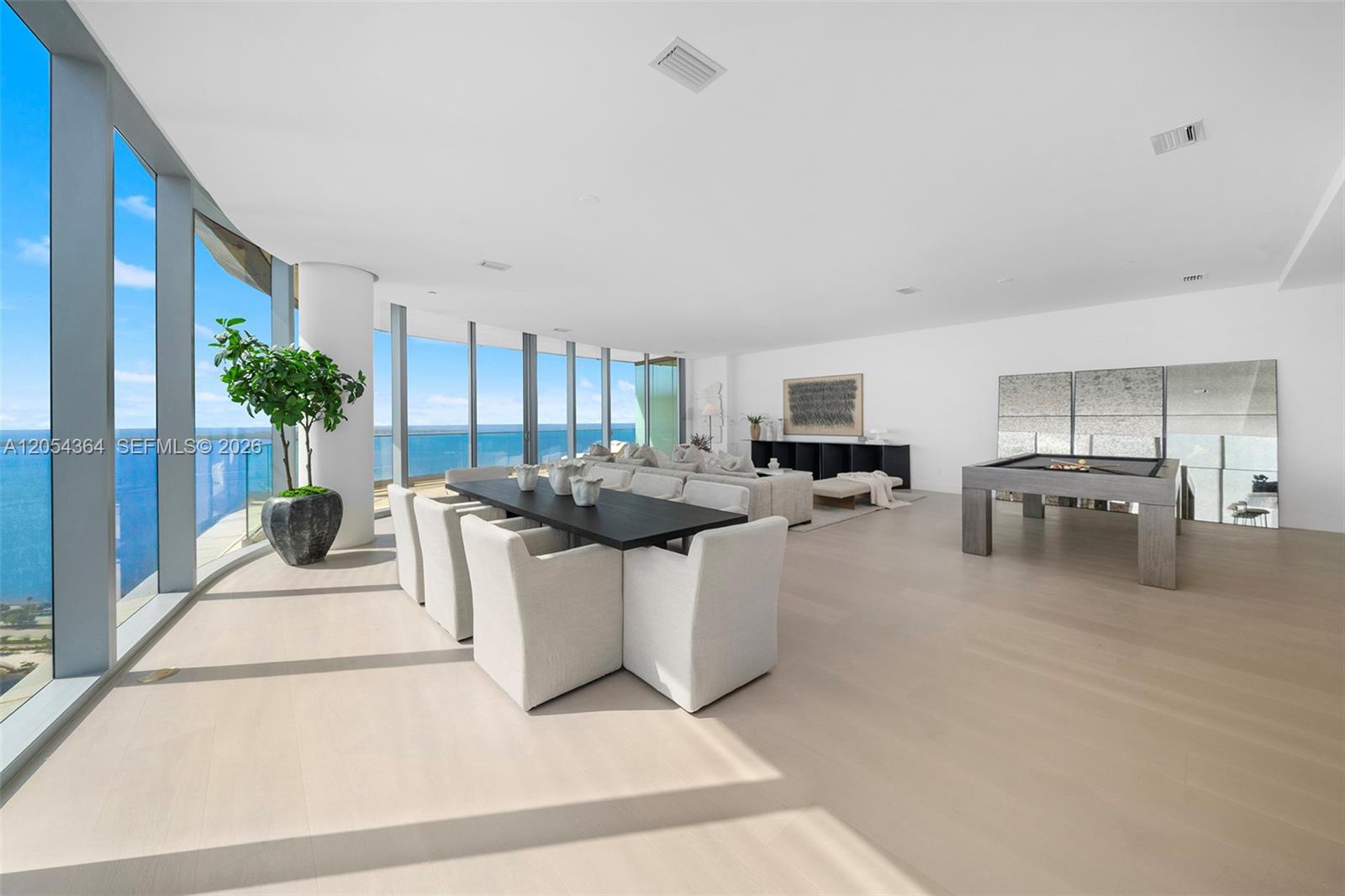 A spacious, modern living and dining area features floor-to-ceiling windows with ocean views — 175 SE 25th Rd # 4001, Miami FL 33129, MIAMI, FL