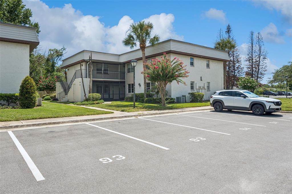 A two-story apartment building with a parking lot in the foreground — 93 WINDTREE LANE UNIT 102, WINTER GARDEN, FL
