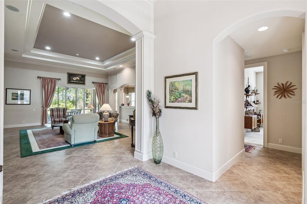A tiled entryway leads into a living room with a tray ceiling and large windows — 322 BELLINGRATH TERRACE, DELAND, FL