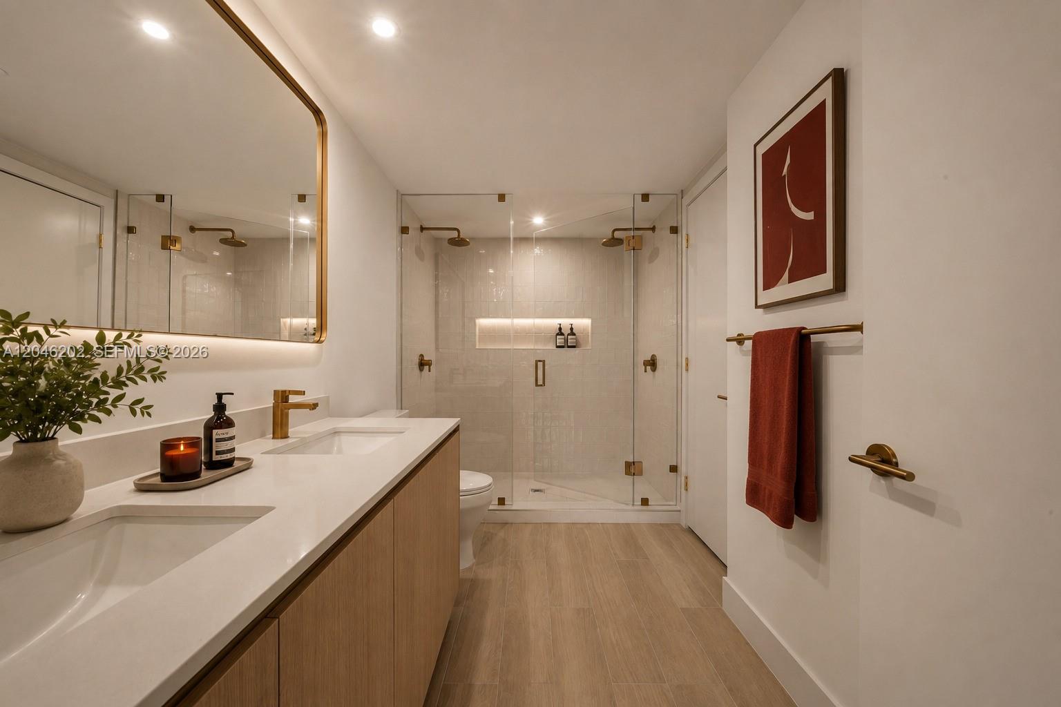 A modern bathroom features a double vanity, a glass-enclosed shower, and light wood cabinetry — 90 NE 32nd # 404, Miami FL 33127, MIAMI, FL