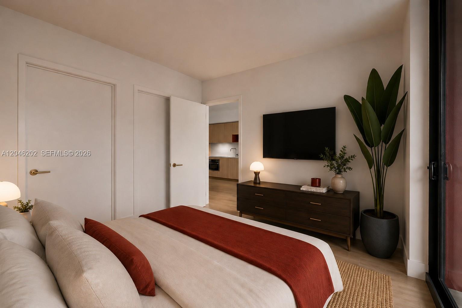 A bedroom features a bed with a red runner, a dark wood dresser, and a television — 90 NE 32nd # 404, Miami FL 33127, MIAMI, FL