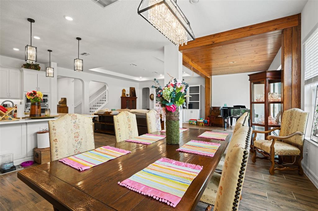 A dining area features a wooden table with patterned chairs and a crystal chandelier — 6170 MARSH TRAIL DRIVE, ODESSA, FL