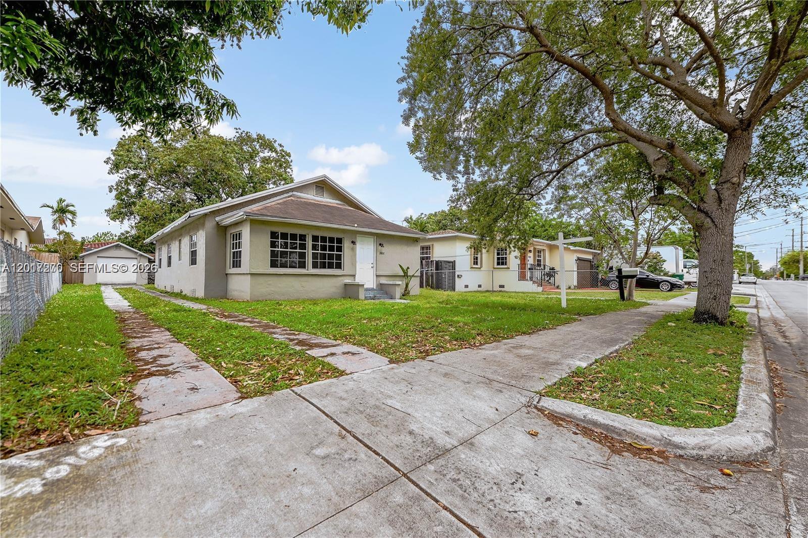 A single-story house with a concrete driveway and a front lawn under large trees — 2800 SW 16th Ter, Miami FL 33145, MIAMI, FL