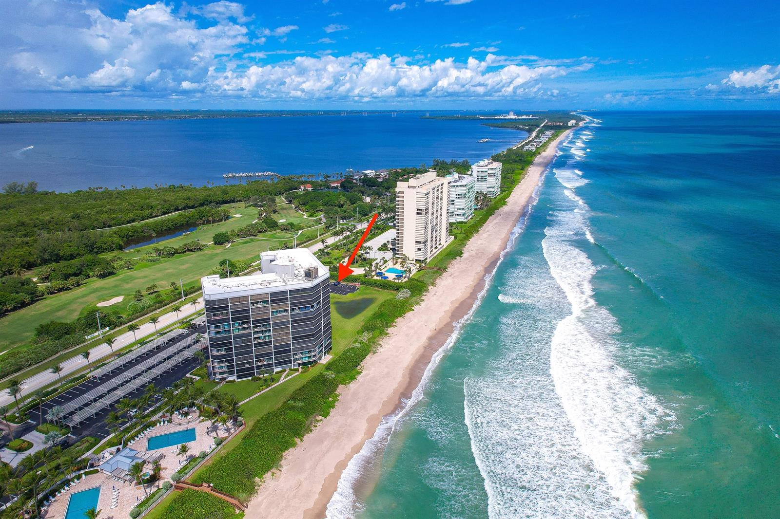 Aerial view of a coastal high-rise building with a beach and golf course nearby — 8800 S Ocean Drive # 1102, Jensen Beach FL 34957, JENSEN BEACH, FL