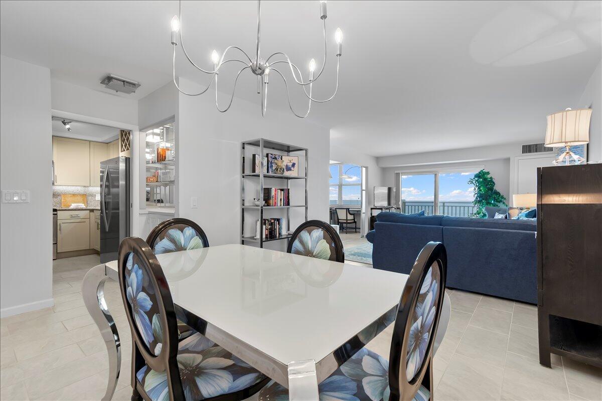 A dining area with a white table and floral chairs opens into a living room — 4511 S Ocean Boulevard # 805, Highland Beach FL 33487, HIGHLAND BEACH, FL