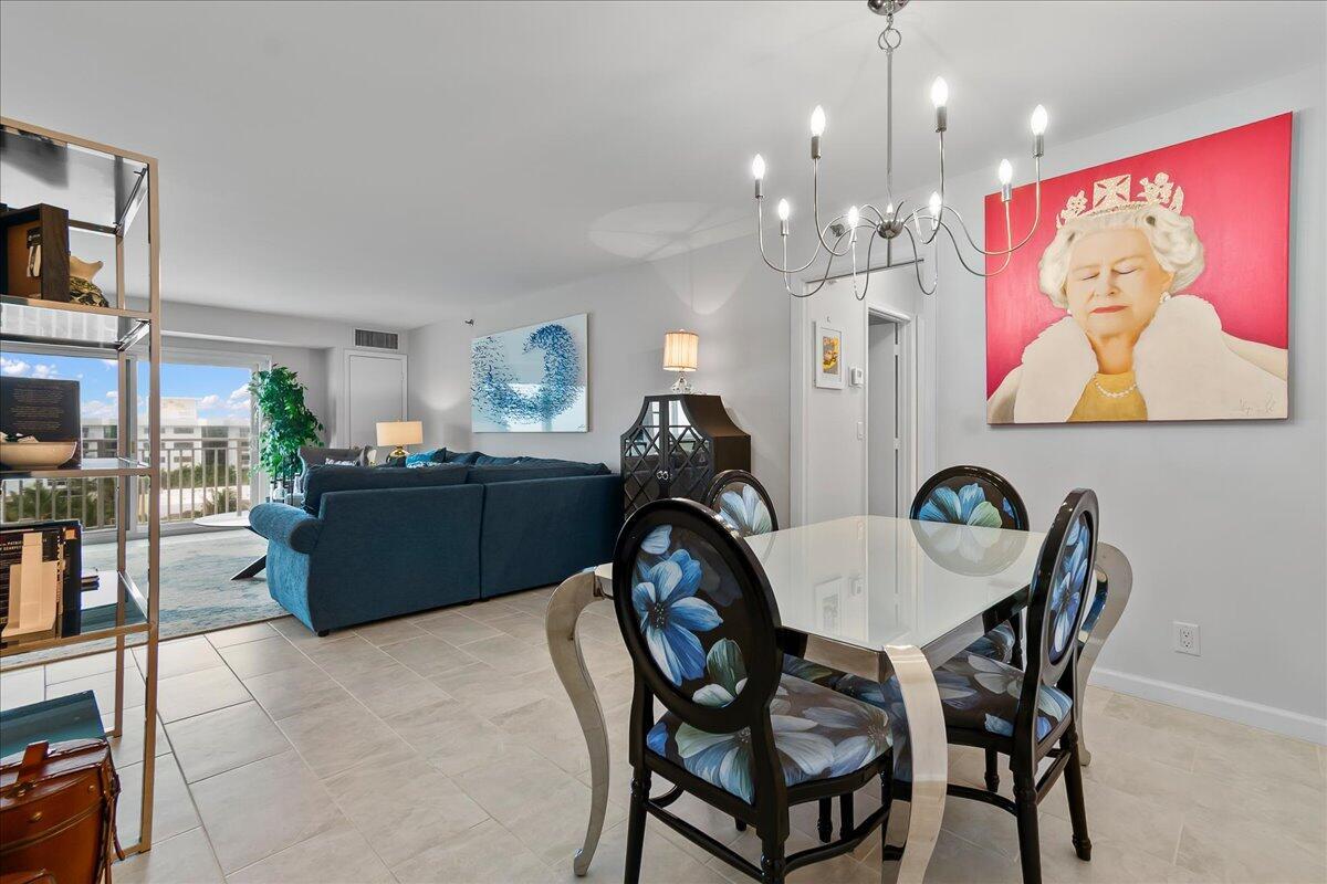 A dining area with a glass table and floral chairs sits before a living room — 4511 S Ocean Boulevard # 805, Highland Beach FL 33487, HIGHLAND BEACH, FL