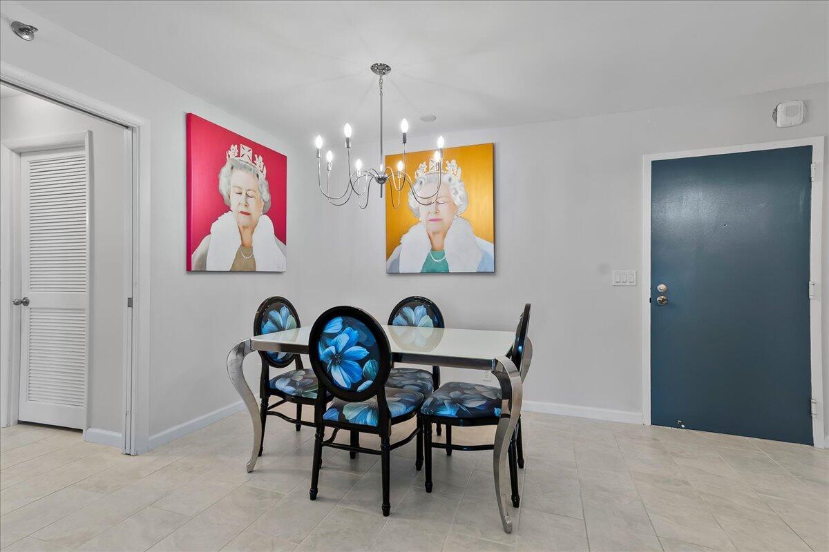 A dining area features a glass table, four floral chairs, and two portraits of Queen Elizabeth — 4511 S Ocean Boulevard # 805, Highland Beach FL 33487, HIGHLAND BEACH, FL