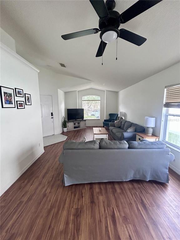 A living room features wood-look flooring, a ceiling fan, and a gray sofa — 1061 PORTMOOR WAY, WINTER GARDEN, FL