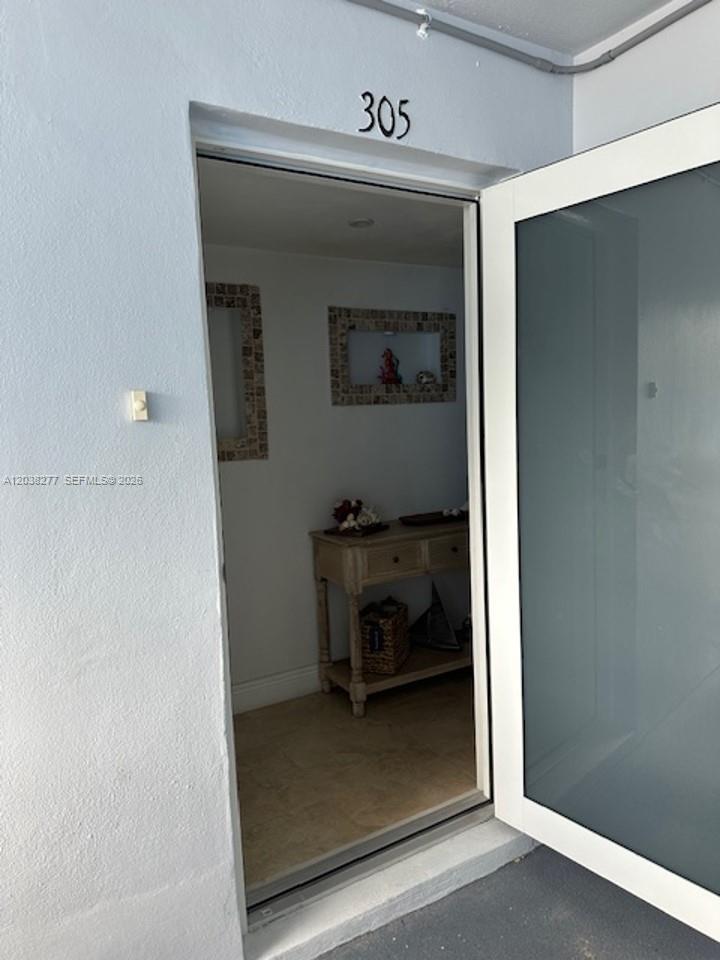 An open door reveals a small entryway with a console table and wall decor — 320 S Surf Rd # 305, Hollywood FL 33019, HOLLYWOOD, FL