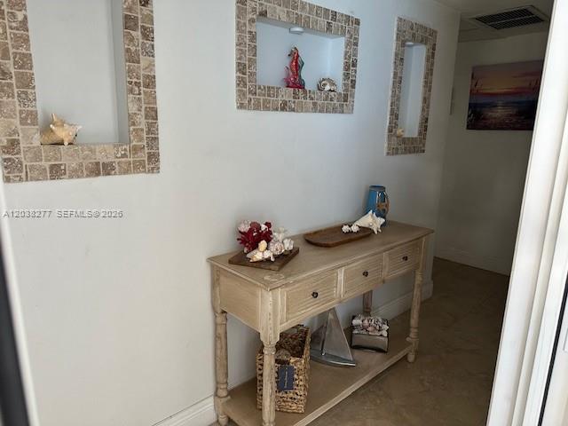 A hallway features a wooden console table, decorative wall niches, and coastal-themed decor — 320 S Surf Rd # 305, Hollywood FL 33019, HOLLYWOOD, FL