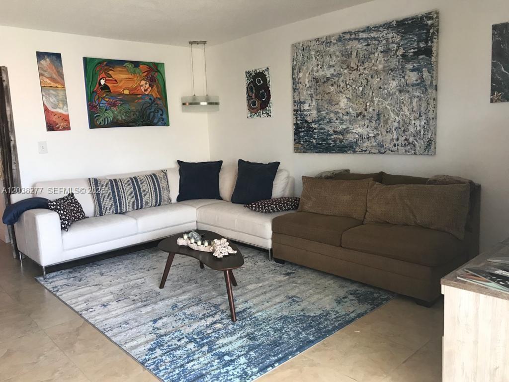 A living room features a white sectional sofa, a brown sofa, and abstract wall art — 320 S Surf Rd # 305, Hollywood FL 33019, HOLLYWOOD, FL