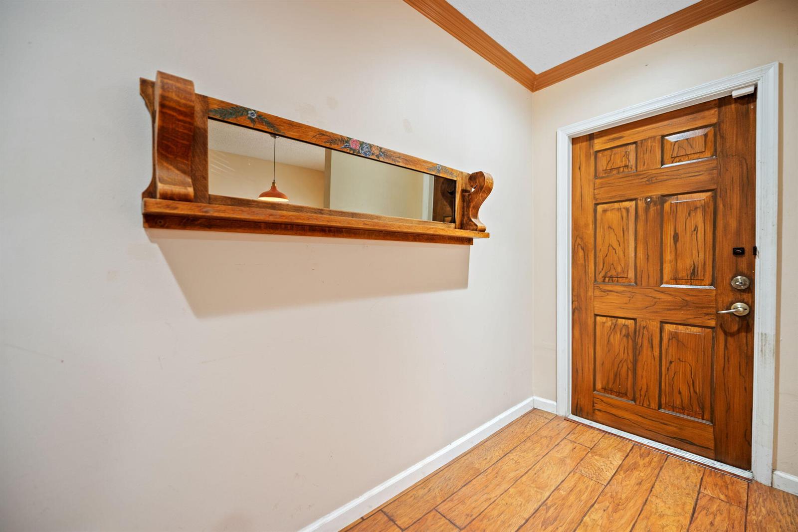 An entryway features a wooden door, wood-look flooring, and a decorative wall-mounted mirror — 2481 NW 98th Lane, Sunrise FL 33322, SUNRISE, FL