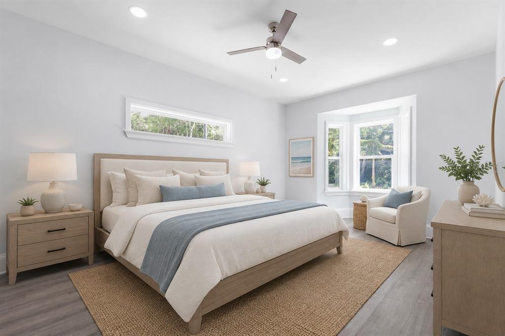 A bright bedroom features a king bed, a bay window, and light wood furniture — 117 HERNANDEZ AVENUE, PALM COAST, FL