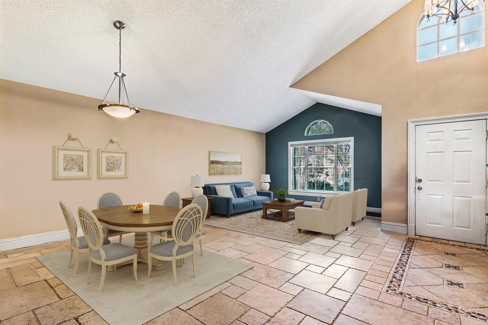 A living and dining room features vaulted ceilings, tile flooring, and a dark accent wall — 2224 Soundings Court, FL 33413, FL