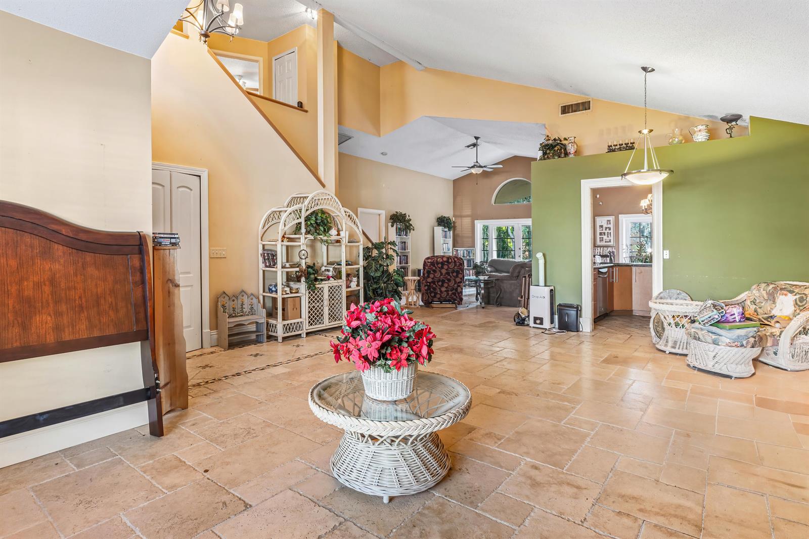 A spacious living room features tile flooring, vaulted ceilings, and a green accent wall — 2224 Soundings Court, FL 33413, FL