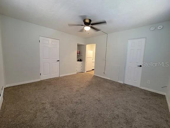 A carpeted bedroom features a ceiling fan, two white doors, and an open doorway — 820 8TH AVENUE S UNIT E, ST PETERSBURG, FL