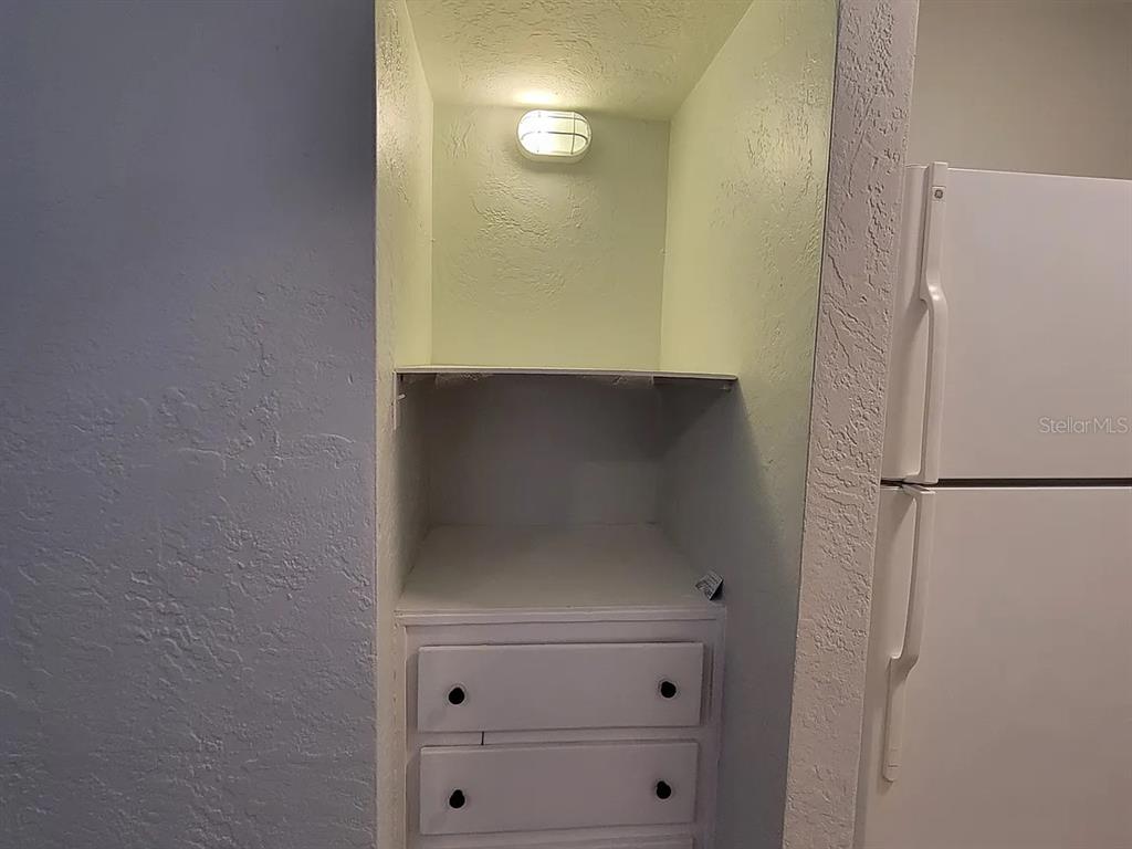 A recessed kitchen nook features a built-in shelf, two drawers, and an overhead light fixture — 820 8TH AVENUE S UNIT E, ST PETERSBURG, FL