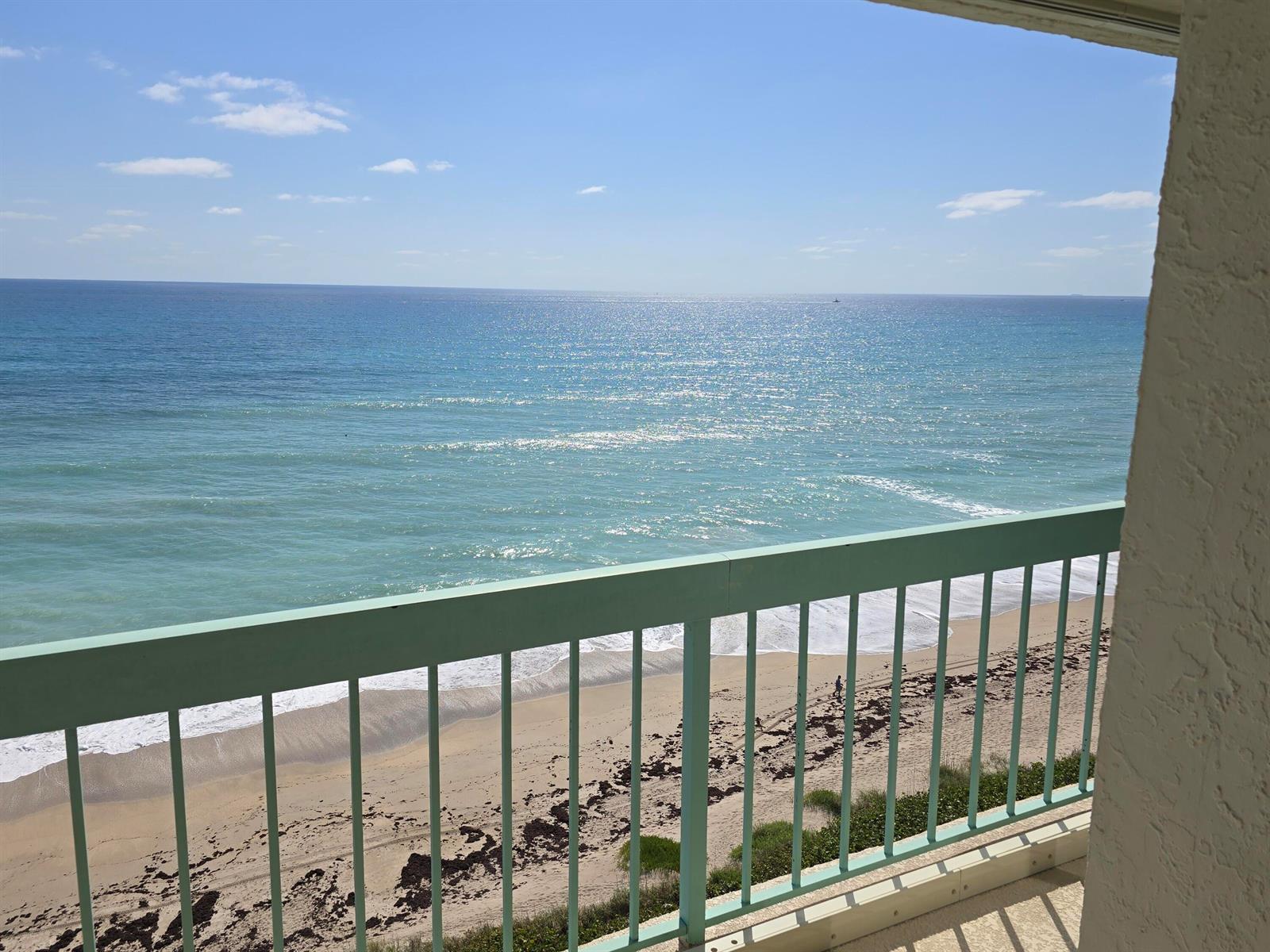A view of the ocean and beach from a balcony with a green metal railing — 9940 S Ocean Drive # 1005, Jensen Beach FL 34957, JENSEN BEACH, FL