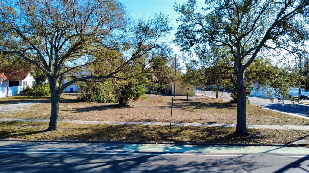 A vacant, grassy lot sits between two large trees along a paved street — 2762 1ST AVENUE S, ST PETERSBURG, FL